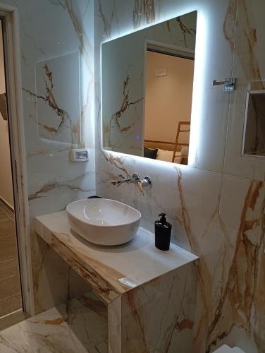 a bathroom with a sink and a mirror at Milto's Rooms in Himare