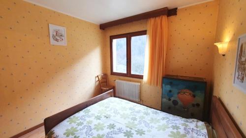 a bedroom with a bed and a window at La Staulette in Queige