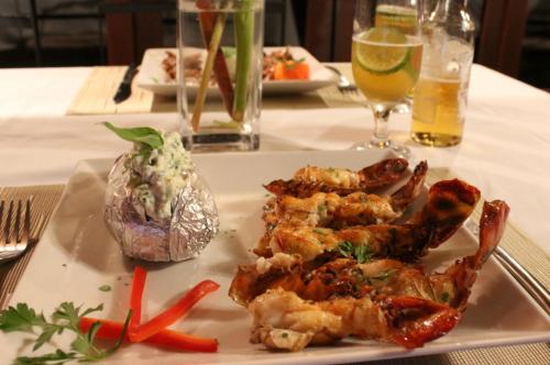 a plate of food with chicken and vegetables on a table at Villa Côté Sud Pousada De Charme in São Miguel dos Milagres