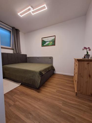 a bedroom with a bed and a dresser in it at Ferienwohnung Hahnenblick in Hahnenbach