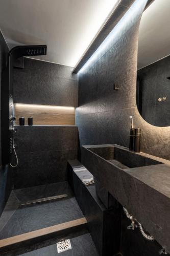 a black bathroom with a sink and a mirror at Apartments Nina in Athens