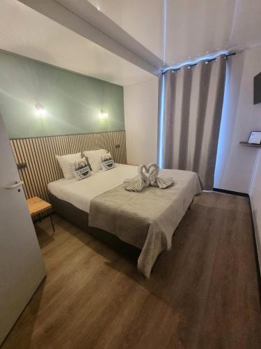 a bedroom with a bed with a bow on it at L'Auberge d'Eygliers in Eygliers