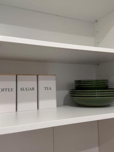 a shelf with three books and a plate on it at City Apartment in Lörrach