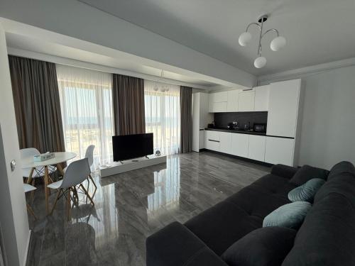 a living room with a couch and a table at Seaside Escape - Luxury Apartment in Năvodari