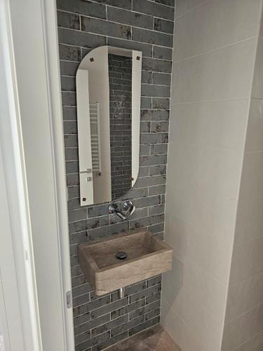a bathroom with a sink and a mirror on a brick wall at Penthouse sarra in Kelibia