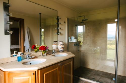 a bathroom with two sinks and a shower at The Englishman's Villa Evia in Perivólia