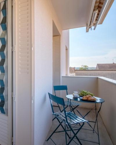 a small balcony with a table and two chairs at Le cottage roannais in Roanne