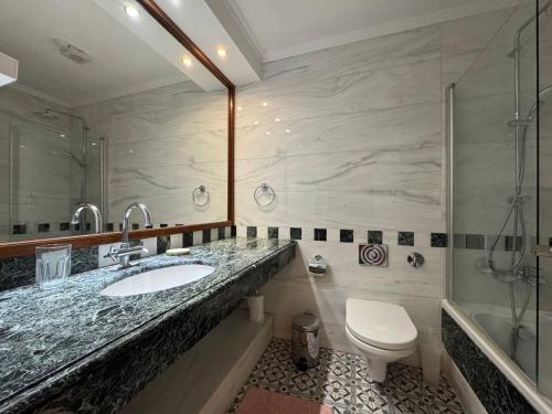 a bathroom with a sink and a toilet and a shower at Beach villa Aurelia in Neo Chorio