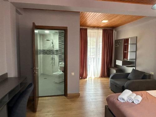 a living room with a glass door to a bathroom at Hotel Mansarda Mestia in Mestia