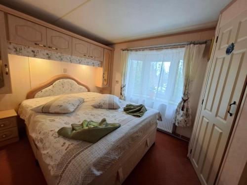 a bedroom with a bed with two towels on it at Ezüst fenyő vendégház in Borzont