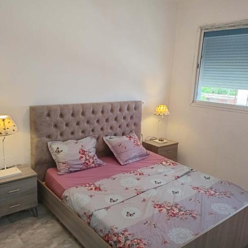 a bedroom with a bed with pink sheets and pillows at Littlhouse in Rafrāf