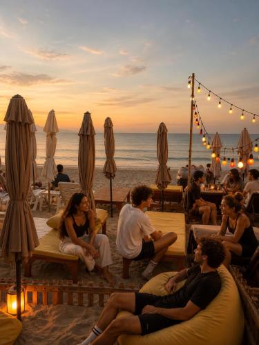 a group of people sitting on the beach at sunset at Noahs Ark in Lamai