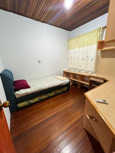 a small room with a bed and a desk at Lingkudau Homestay in Keningau