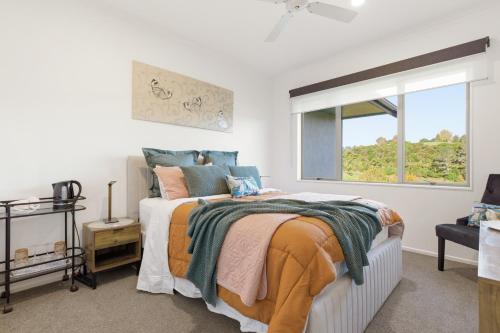 a bedroom with a bed and a window at McLaren Lake View in Tauranga