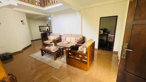 a living room with a couch and a table at Ceylon Mist Villa in Narandanda