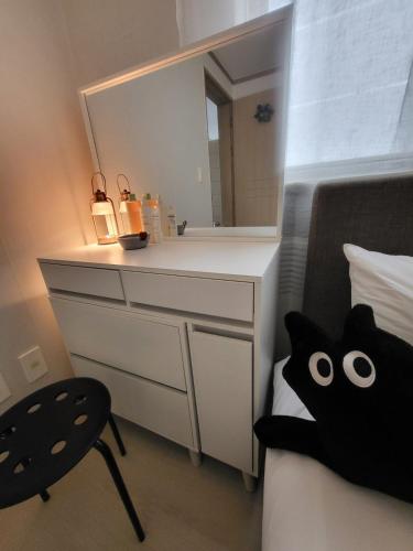 a bedroom with a dresser and a mirror and a bed at 씨하우스 501호 in Hakch'ŏn-dong