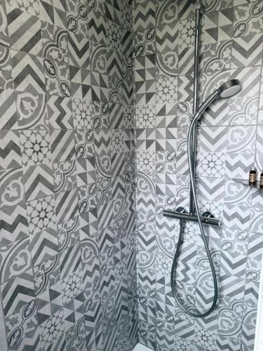 a shower in a bathroom with a patterned shower curtain at Logis des pêcheurs in Meschers-sur-Gironde