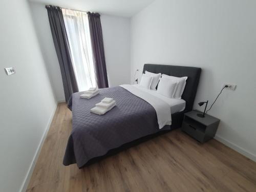 a bedroom with a bed with two towels on it at Sterling House in Timişoara