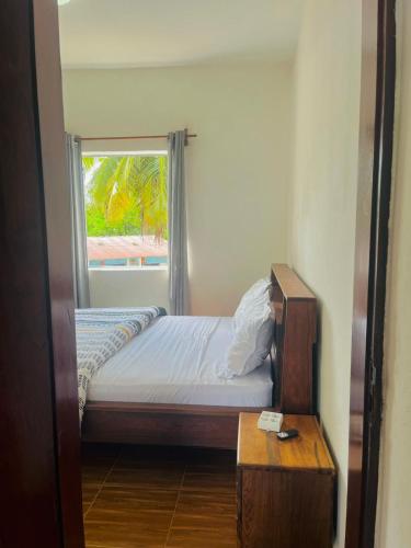 a small bedroom with a bed and a window at Chez Pauline in Sainte Marie