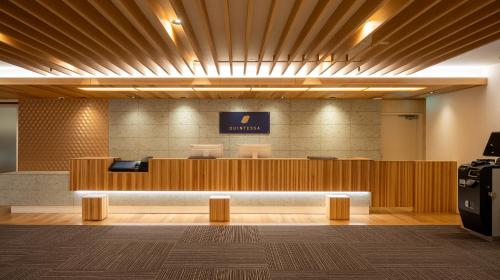 an office lobby with a reception desk and a sign on the wall at Quintessa Hotel Akita in Akita