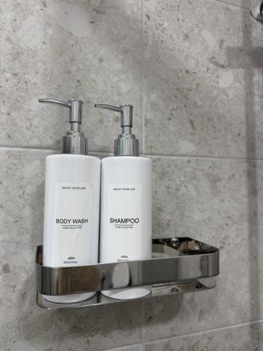 two bottles of soap on a shelf in a bathroom at SILVIA apartment 101 in Druskininkai