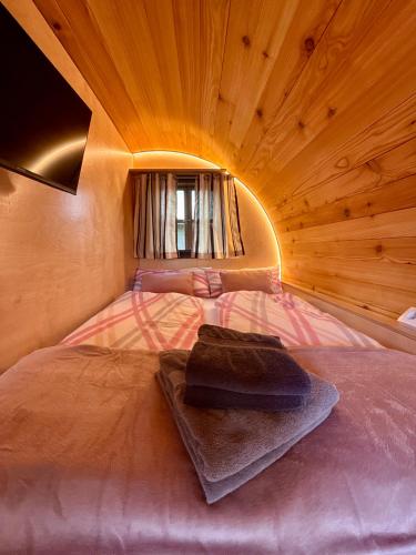 a bed in a room with a wooden ceiling at Schaumburger Fass in Rinteln