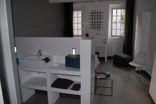a white bathroom with a sink and a mirror at Le 2 in Vence