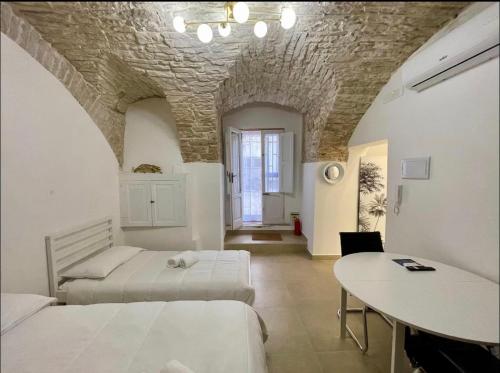 a bedroom with two beds and a table in it at Casa-Torre Normanna in Bitonto