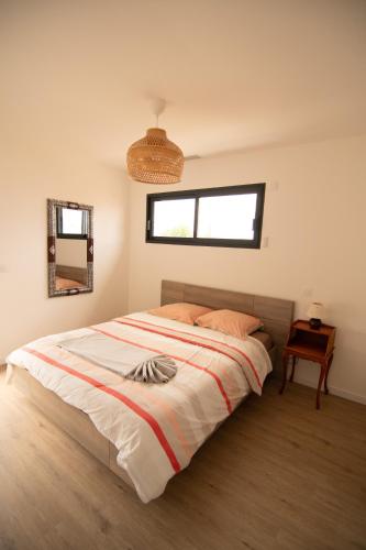 a bedroom with a large bed with a window at Villa au calme avec piscine privée - Lac de Jouarres in Olonzac