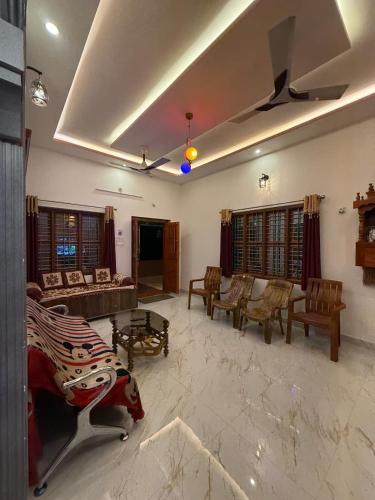a large living room with a couch and chairs at Deepa HomeStay in Dharmastala