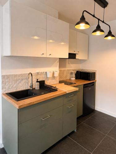 a kitchen with white cabinets and a sink at Apartamenty Przy Forcie in Kłodzko