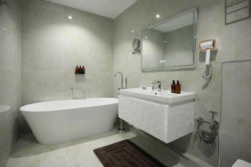 a bathroom with a tub and a sink and a mirror at Рамада Нукус in Nukus