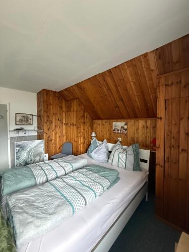 a large white bed in a room with wooden walls at Privatzimmer in Trieben