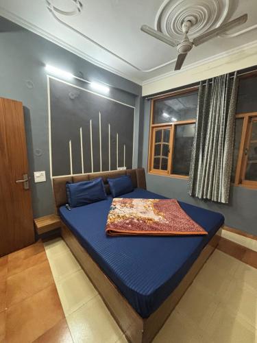 a bedroom with a blue bed in a room at Hotel Atithyam in Solan