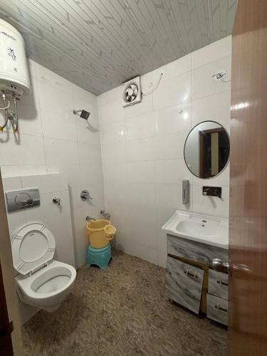 a bathroom with a toilet and a sink at Hotel Atithyam in Solan
