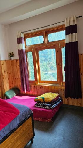 ein Schlafzimmer mit einem Bett und einem Fenster in der Unterkunft FORMOSA Cafe Hostel KASOL GOA in Kasol