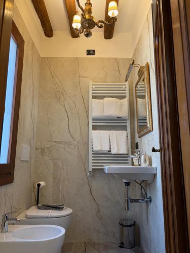 a bathroom with a sink and a toilet and a mirror at Ca' Pierre in Venice