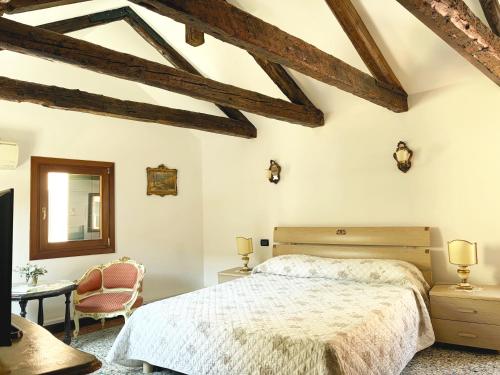 a bedroom with a bed and a chair and a mirror at Ca' Pierre in Venice