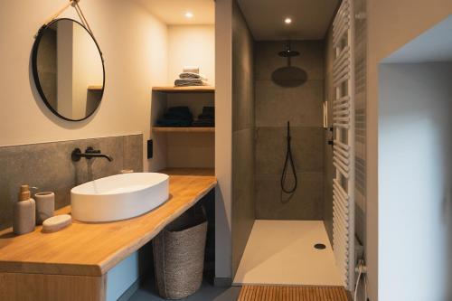 a bathroom with a sink and a mirror at Stone Barn Menil Sauna & Nordic Bath in Ardennes in Hotton