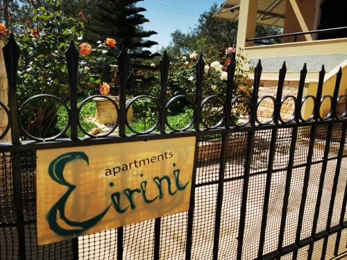 a sign on a fence in front of a garden at Studio Apartments Eirini in Pyrgi Thermis