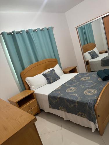 a bedroom with a bed and a mirror at Casa Amélia in Cidade Velha