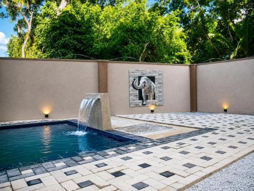 an elephant picture on a wall next to a pool with a fountain at Araliya Villa in Tangalle