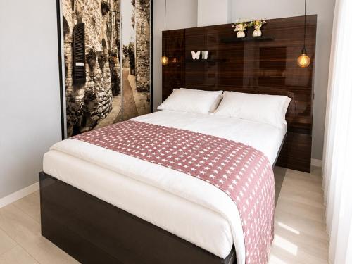 a bedroom with a bed with a red and white blanket at Kwartał Dominikański in Kamień Pomorski
