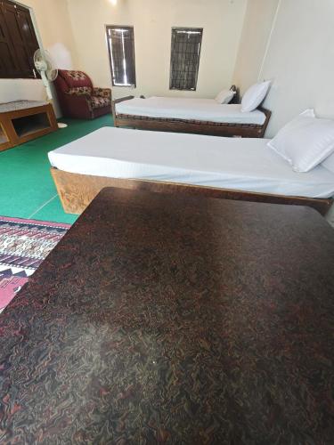 a bedroom with two beds and a rug at Gatlang Backpackers in Trisūli Bāzār