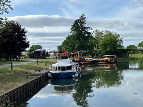 a boat is docked on a river with other boats at Chalet in Fleury-sur-Loire