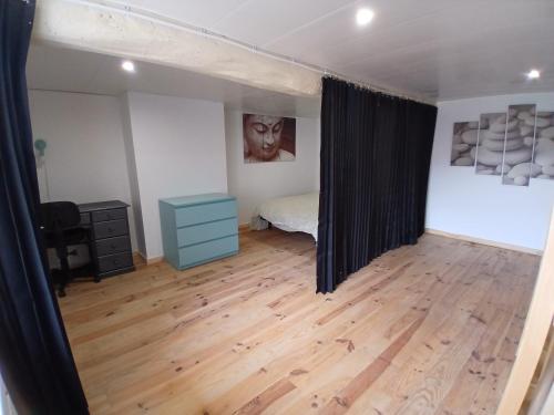 a bedroom with a bed and a wooden floor at Chambres d'hôtes in Annoisin-Chatelans