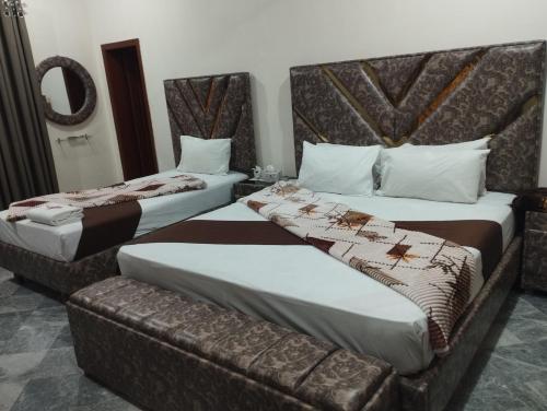 two beds in a hotel room with a couch at Hotel Multan Avenue Multan in Multan