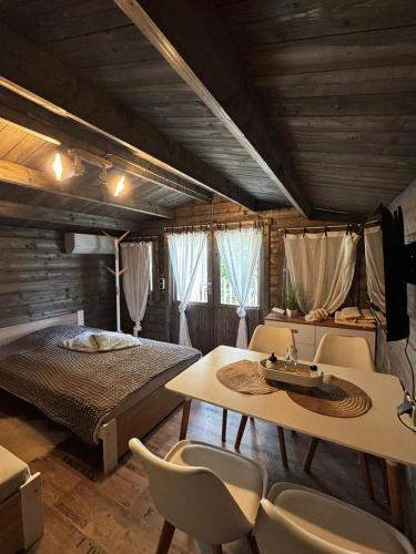a bedroom with a bed and a table and chairs at Forsthäuschen am Ponyhof in Wonsheim