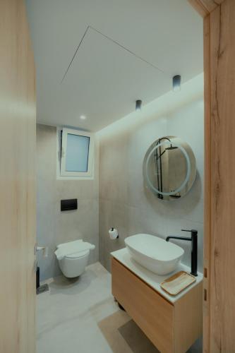 a bathroom with a sink and a toilet and a mirror at Lefka Apartment in Vivari