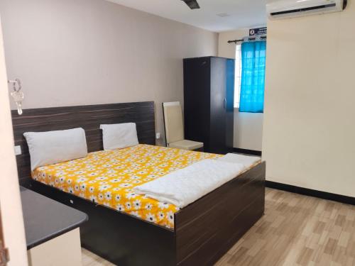 a bedroom with a bed with a yellow blanket on it at AB Merridien in Coimbatore